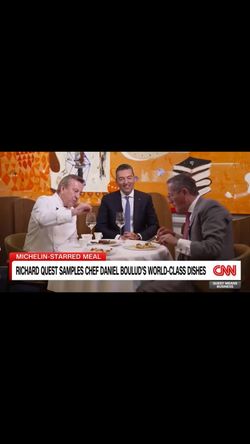 Michelin star restaurant Daniel with patrons sampling gourmet dishes at a table set with wine glasses and fine dining tablew