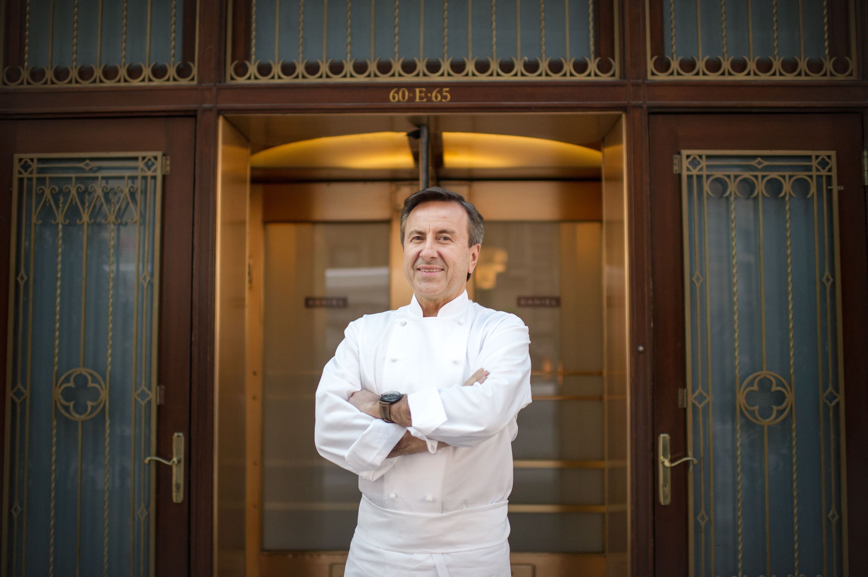 A chef stands confidently outside Daniel, a Michelin star French restaurant on the Upper East Side.
